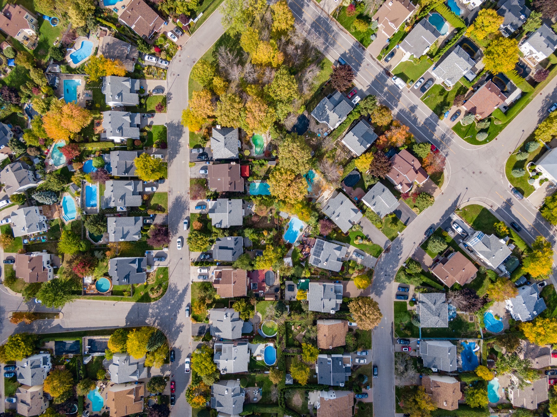 Aerial view of a residential neighborhood with backyard swimming pools.